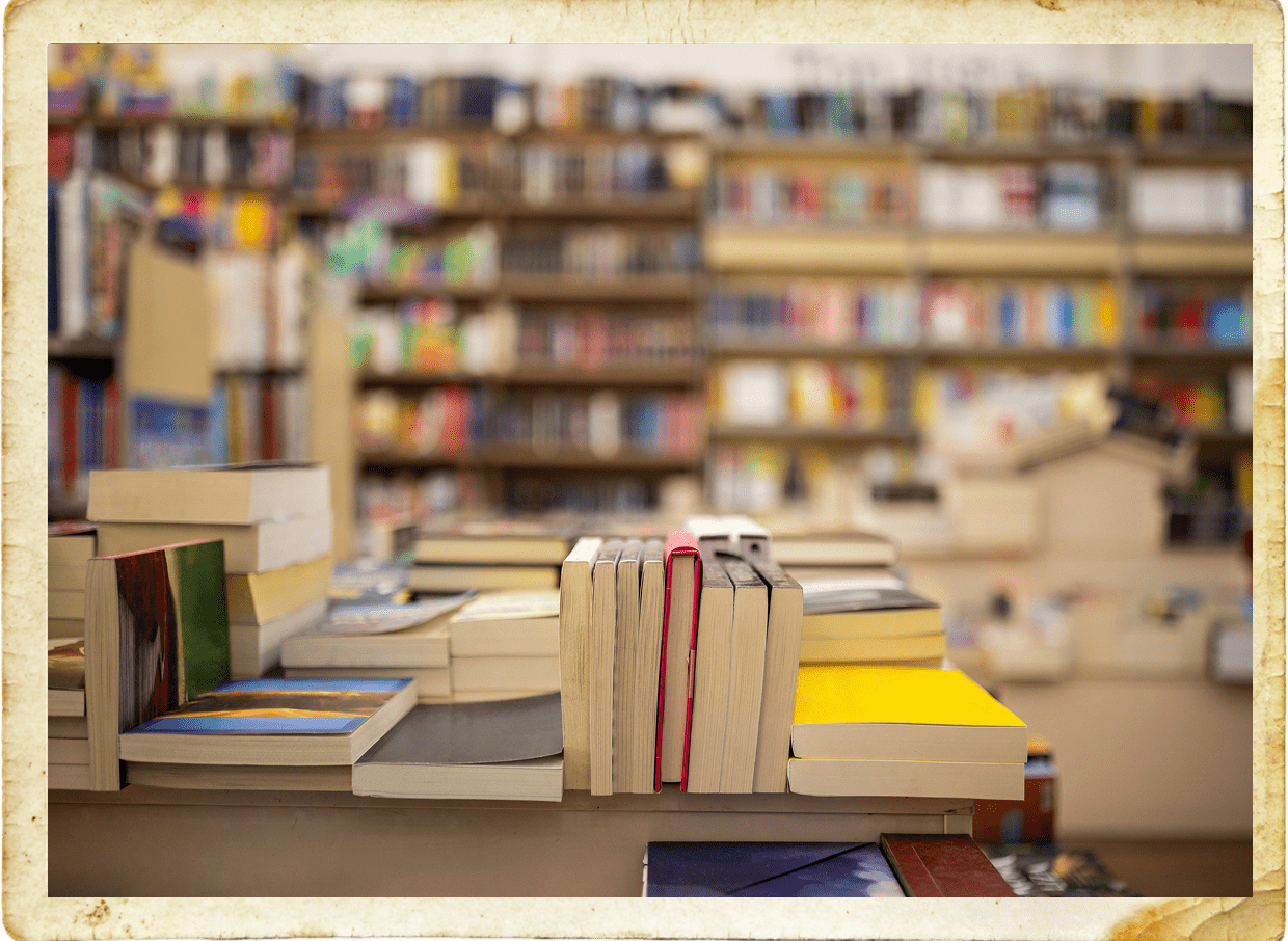 Books stacked on table in library.